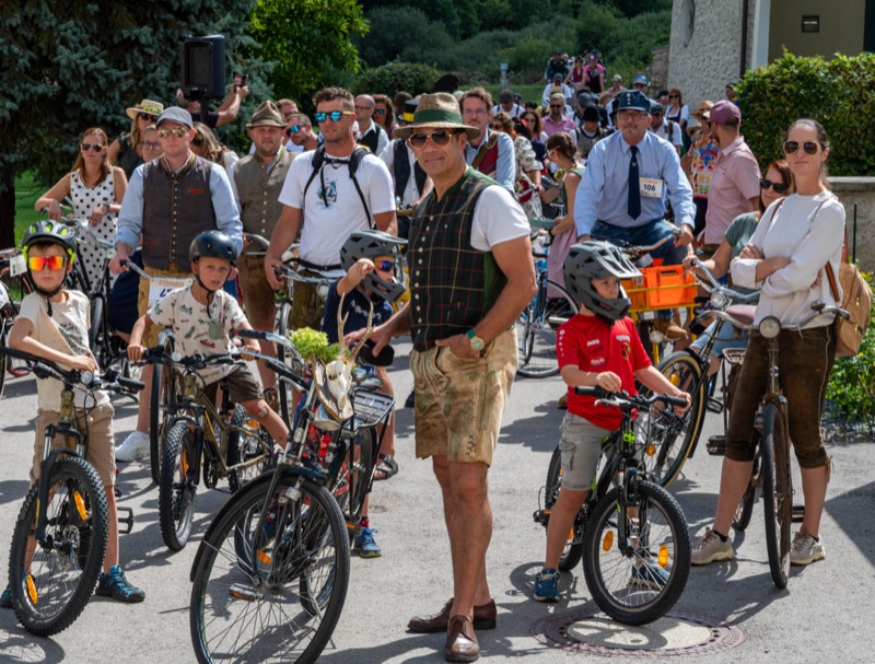 Teilnehmerinnen und Teilnehmer in Retro-Outfits mit ihren Rädern beim Start