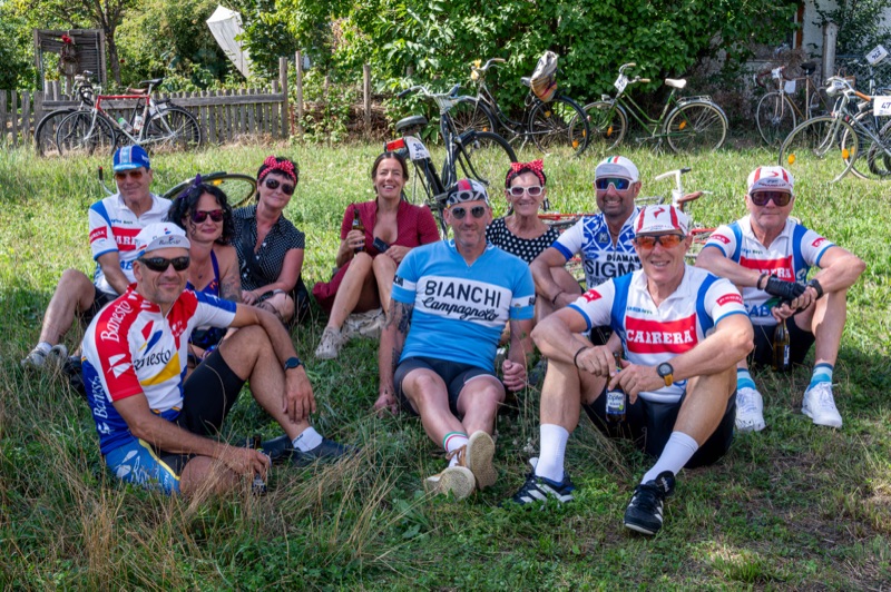 Gruppe in Retro-Radtrikots sitzt gemeinsam in der Wiese