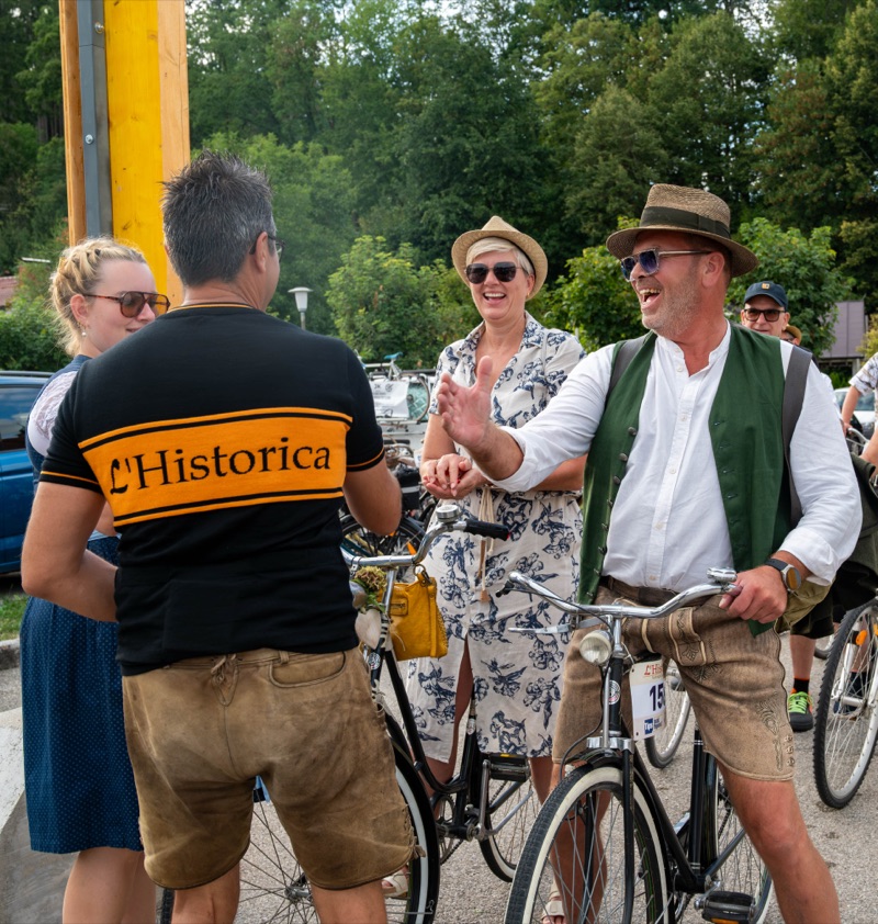 Fahrer im L'Historica-Trikot plaudert mit Radfahrern in Tracht